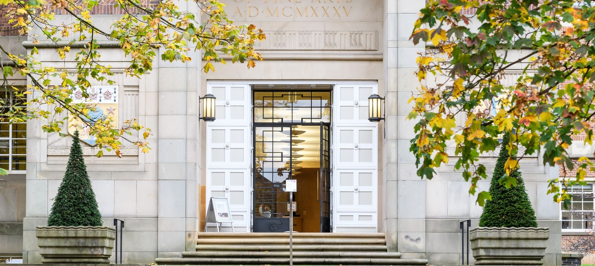 The Barber Institute entrance, with the door open and autumn trees either side.