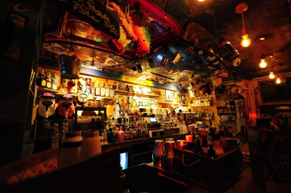 Back Bar of 400 rabbits Shelves filled with seeming glowing bottles of alcoholic beverages caused by the mood lighting under the bar